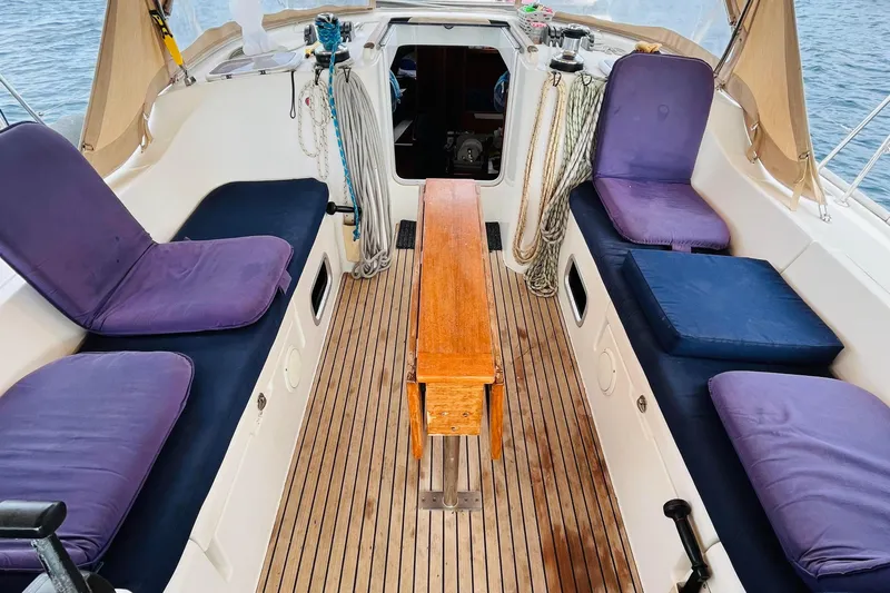  Yacht Photos Pics 2006 Beneteau 473 sailboat cockpit with wooden table and cushioned seating.