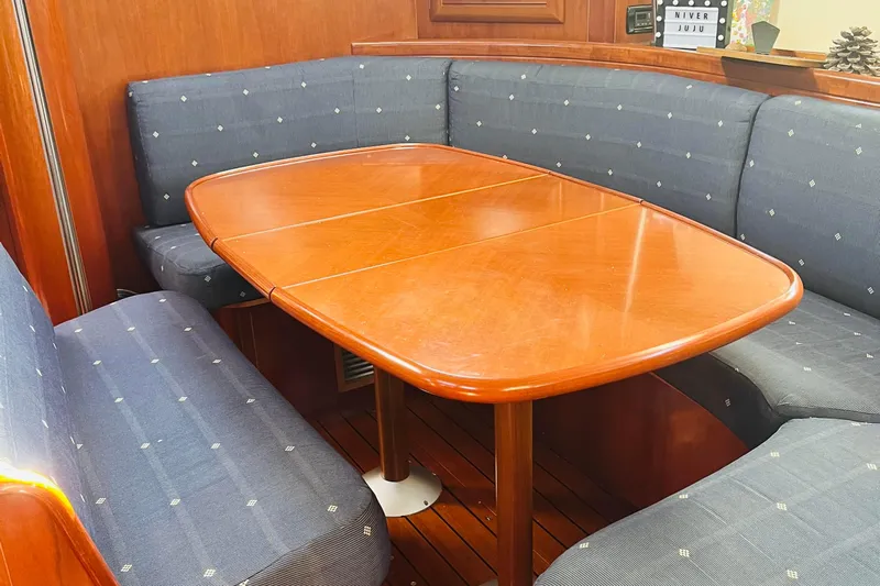  Yacht Photos Pics Interior of 2006 Beneteau 473 yacht with wooden dining table and cushioned seating.