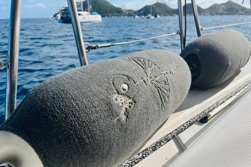  Yacht Photos Pics Beneteau 473 sailboat with embroidered fender covers, ocean and islands in background.
