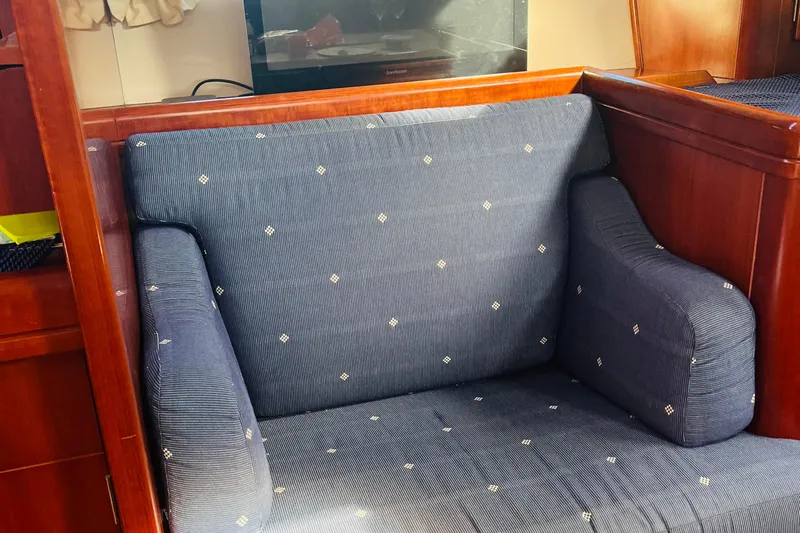  Yacht Photos Pics Blue cushioned seating in 2006 Beneteau 473 yacht interior, featuring wooden paneling.