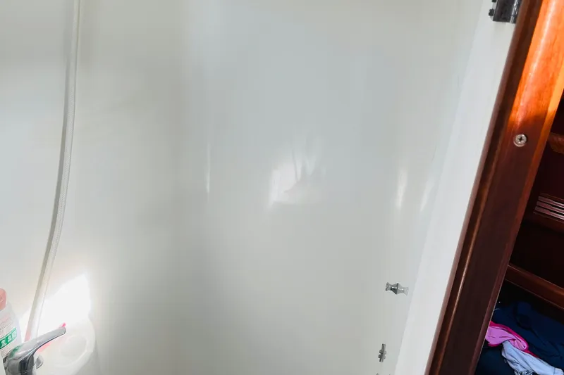  Yacht Photos Pics Shower area inside a 2006 Beneteau 473 yacht, featuring white walls and wooden trim.