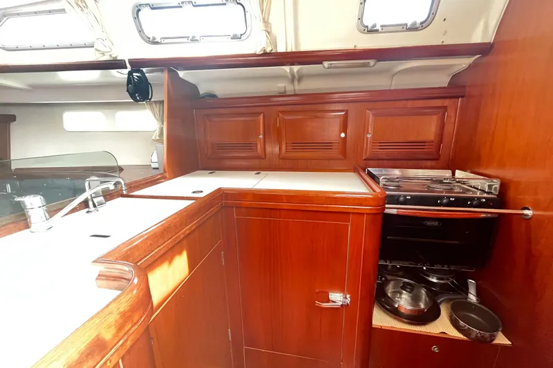  Yacht Photos Pics Luxurious 2006 Beneteau 473 yacht kitchen with wooden cabinetry and modern appliances.