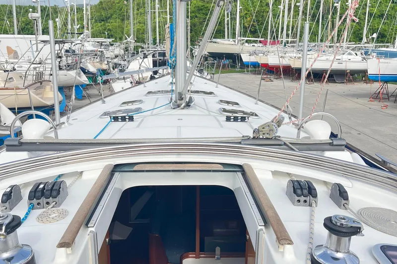  Yacht Photos Pics 2006 Beneteau 473 sailboat deck view in a marina with other boats.