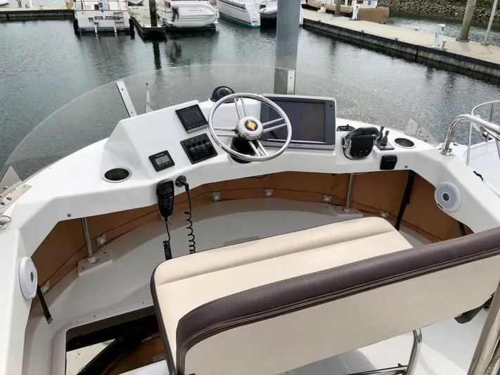The Western Yacht Photos Pics 2014 Ranger Tugs R-31CB helm with steering wheel, controls, and navigation equipment at marina.