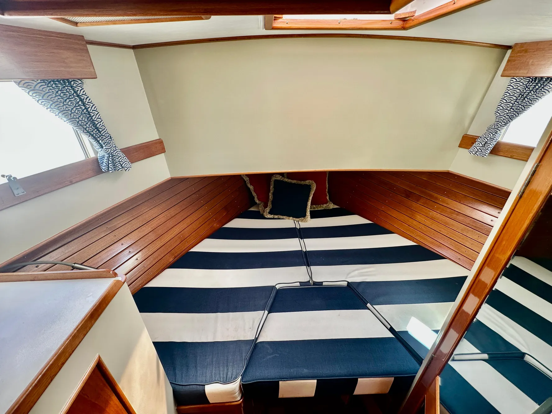 1989 Grand Banks 42 Classic cabin interior with striped bedding and wooden paneling.