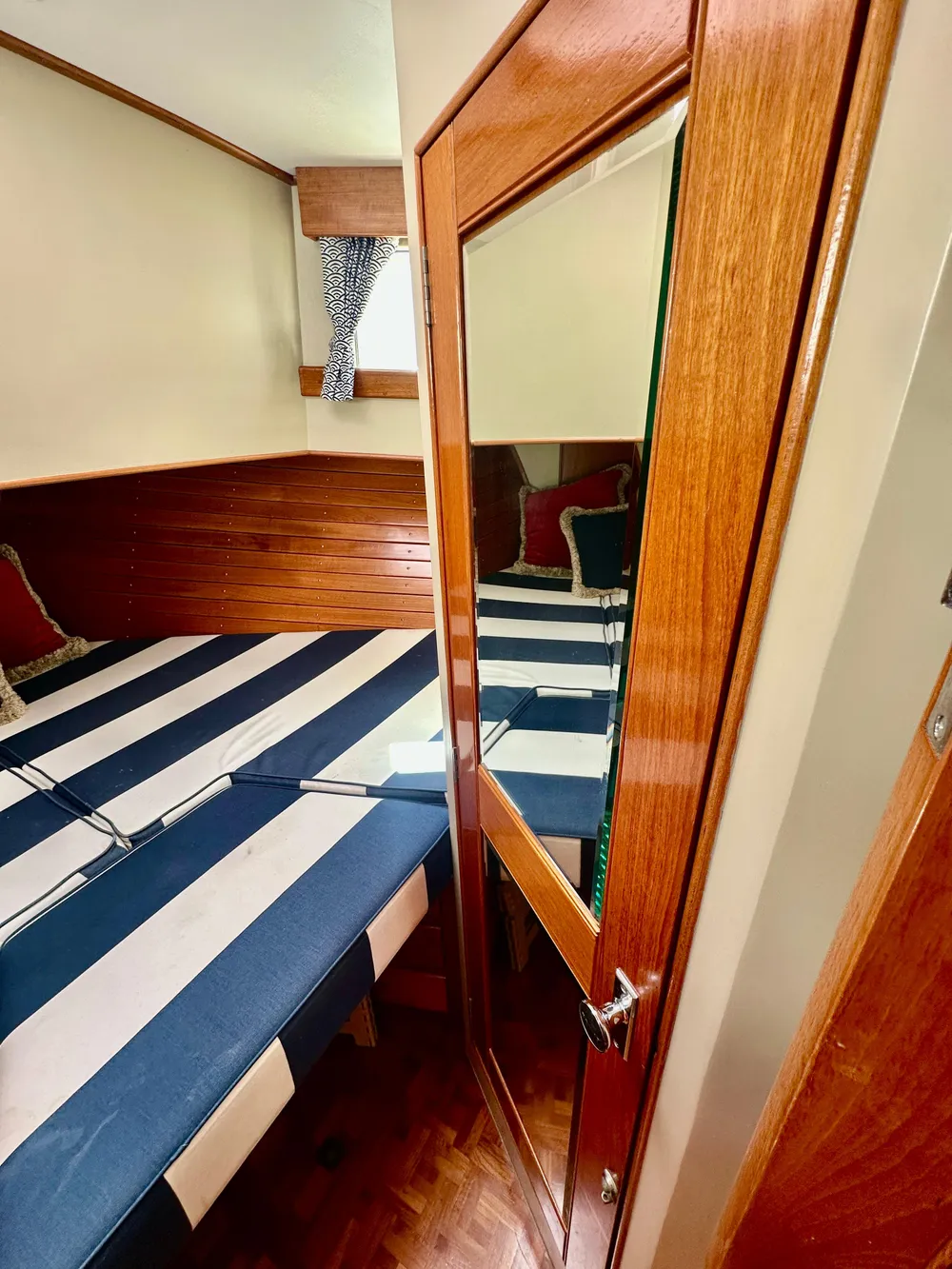 Cozy cabin interior of 1989 Grand Banks 42 Classic with striped bedding and wooden accents.