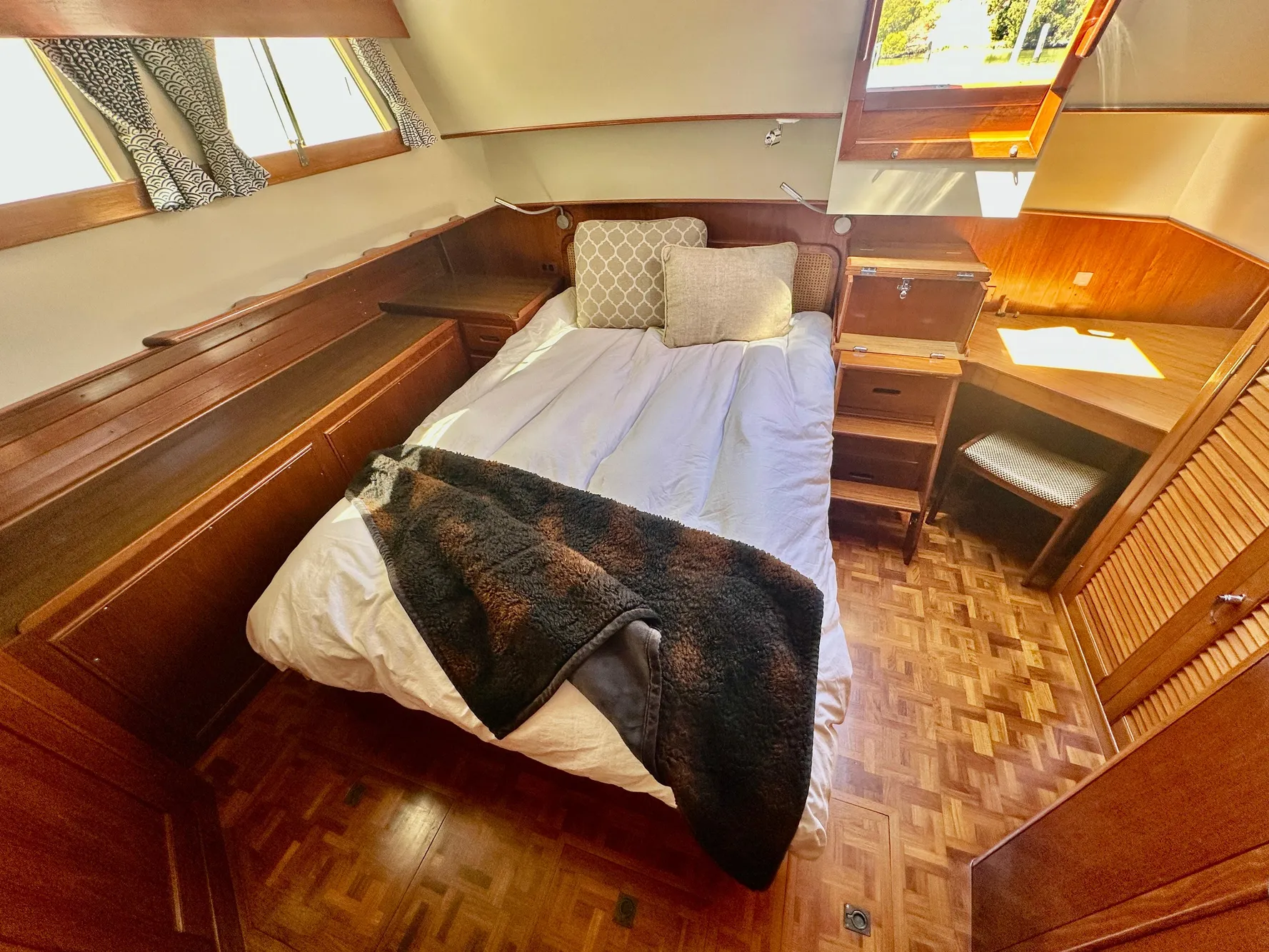 Cozy bedroom in 1989 Grand Banks 42 Classic yacht with wood accents and natural light.