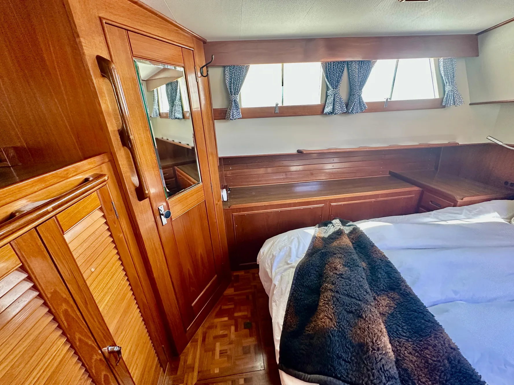 Cozy cabin interior of 1989 Grand Banks 42 Classic with wood paneling and bed.