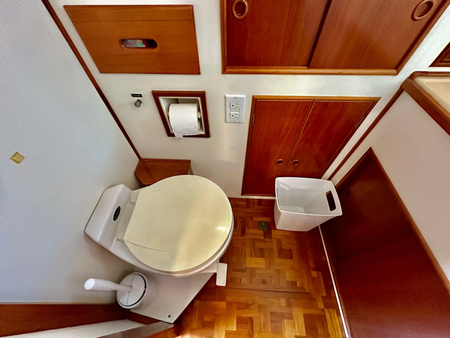 Bathroom interior of 1989 Grand Banks 42 Classic yacht with wooden cabinetry and parquet flooring.