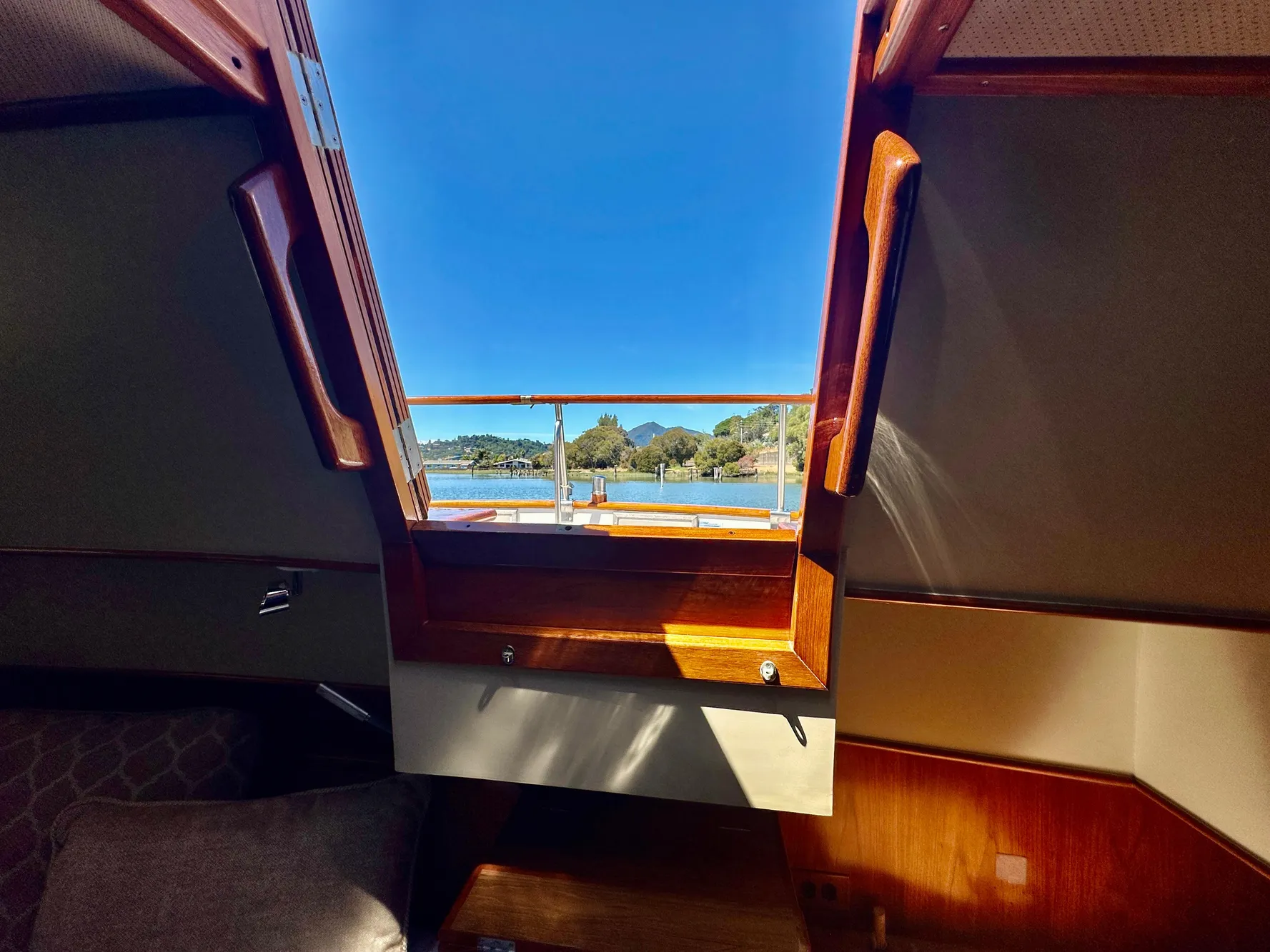 Interior view from a 1989 Grand Banks 42 Classic yacht, showcasing a scenic waterway.