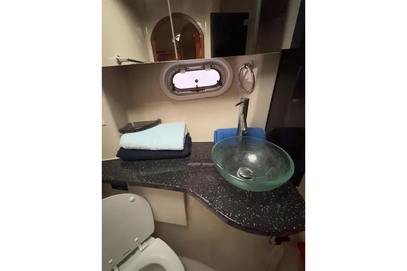  Yacht Photos Pics Luxurious 2007 Four Winns 378 Vista yacht bathroom with modern glass sink and porthole window.