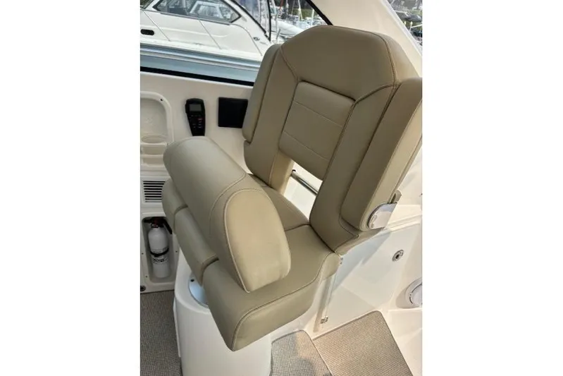 Syd Fishes Yacht Photos Pics 2017 Pursuit OS 325 Offshore boat seat with beige upholstery and armrests.