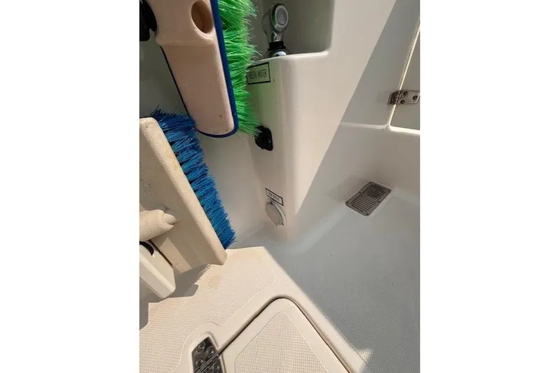 Syd Fishes Yacht Photos Pics 2017 Pursuit OS 325 Offshore boat interior with cleaning brushes and storage compartment.