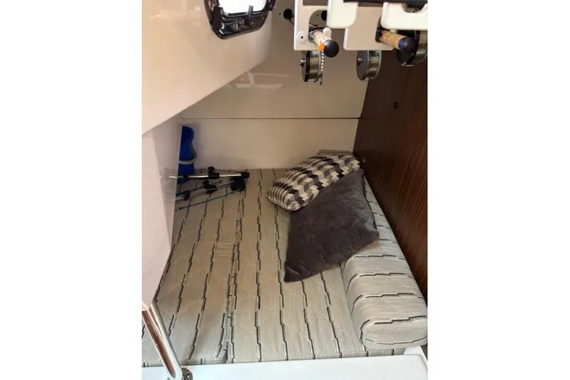 Syd Fishes Yacht Photos Pics 2017 Pursuit OS 325 Offshore cabin interior with cushions and fishing rods.