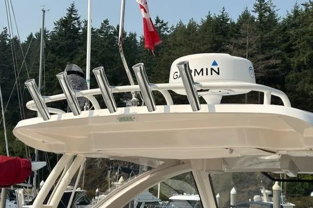 Syd Fishes Yacht Photos Pics 2017 Pursuit OS 325 Offshore boat with Garmin radar, docked near forested shoreline.