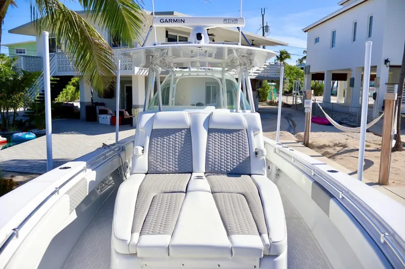  Yacht Photos Pics 2018 Contender 39 Fisharound boat with cushioned seating, docked near tropical homes.