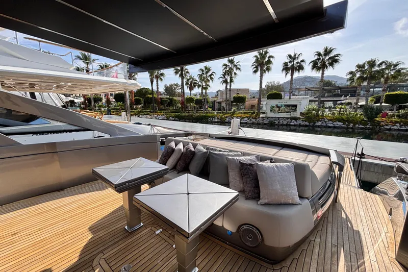  Yacht Photos Pics Luxurious 2019 Pershing 70 yacht deck with elegant seating and scenic waterfront view.