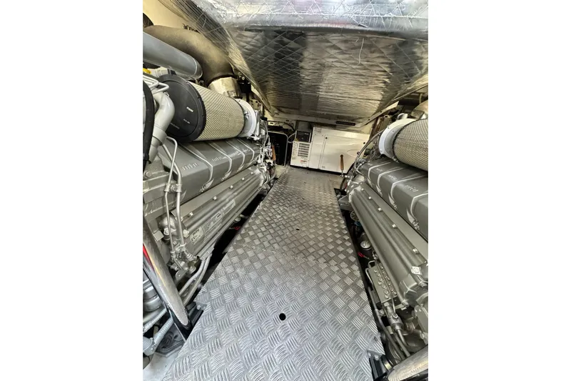  Yacht Photos Pics Engine room of a 2019 Pershing 70 yacht, featuring dual engines and metallic flooring.