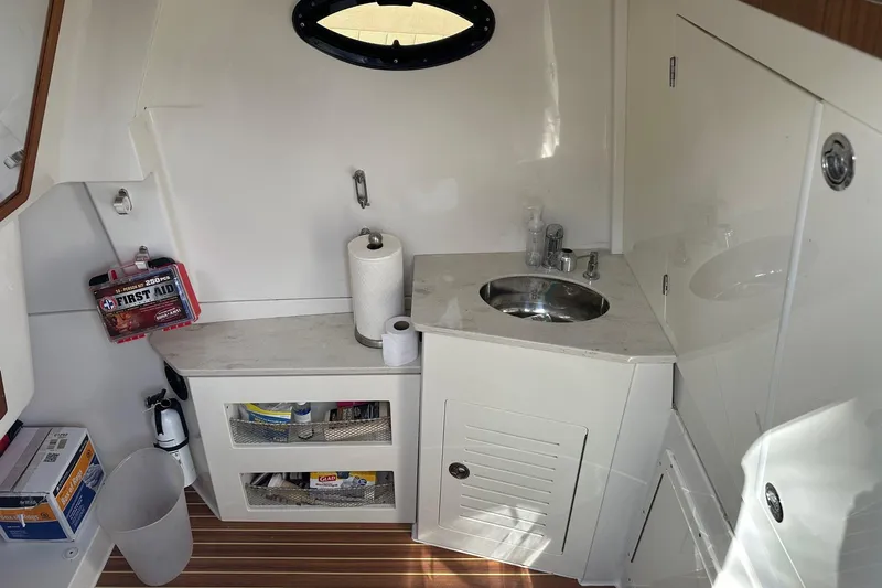  Yacht Photos Pics 2019 Sailfish 360 CC boat interior with sink, first aid kit, and storage shelves.