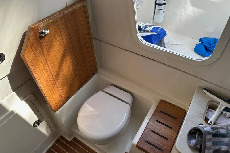  Yacht Photos Pics 2019 Sailfish 360 CC boat interior with toilet, wooden accents, and window view.