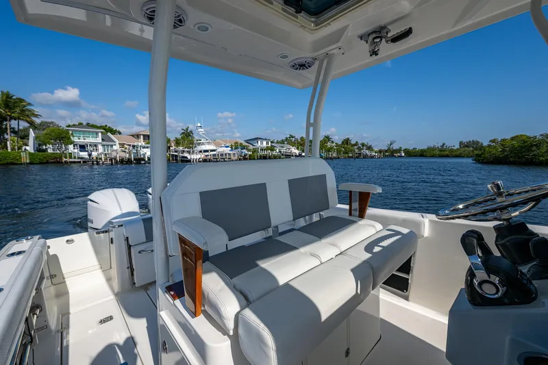  Yacht Photos Pics 2021 Pursuit S 288 Sport boat interior with seating, steering wheel, and waterfront view.