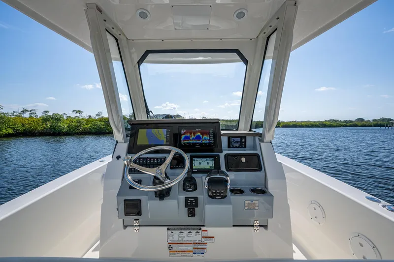  Yacht Photos Pics 2021 Pursuit S 288 Sport boat helm with advanced navigation system on calm water.