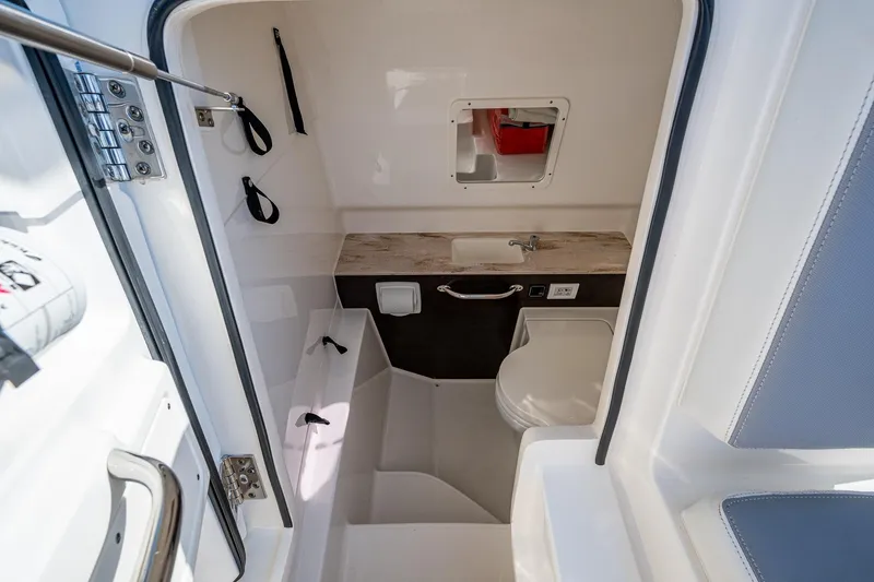  Yacht Photos Pics 2021 Pursuit S 288 Sport boat interior with compact bathroom and sink.