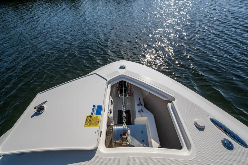  Yacht Photos Pics Bow of 2021 Pursuit S 288 Sport boat with anchor compartment open on water.