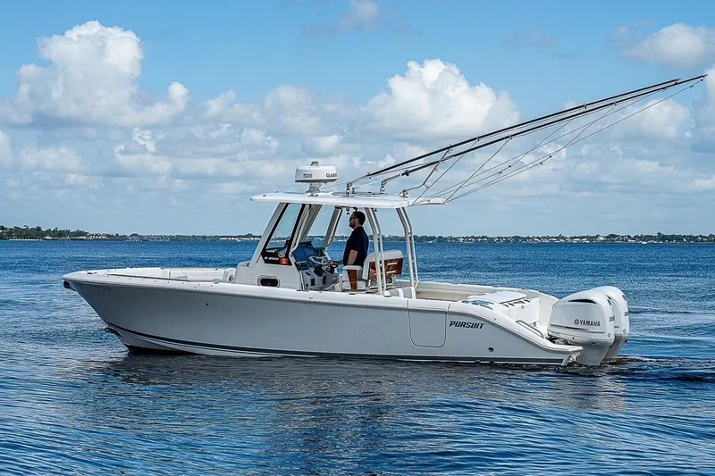  Yacht Photos Pics 2021 Pursuit S 288 Sport boat cruising on a calm blue sea under a clear sky.