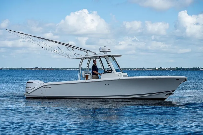  Yacht Photos Pics 2021 Pursuit S 288 Sport boat cruising on a calm, blue ocean under a clear sky.