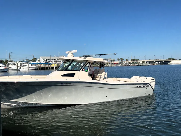  Yacht Photos Pics 2022 Grady-White 376 boat cruising in a marina under clear blue skies.