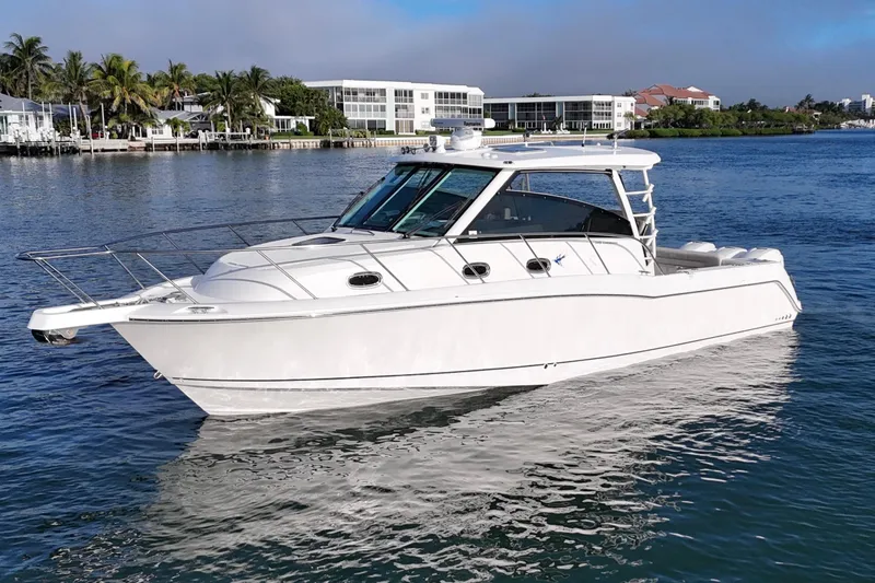 Whaler 345 Conquest - Loaded Yacht Photos Pics 2016 Boston Whaler 345 Conquest boat on calm water, with coastal buildings in the background.