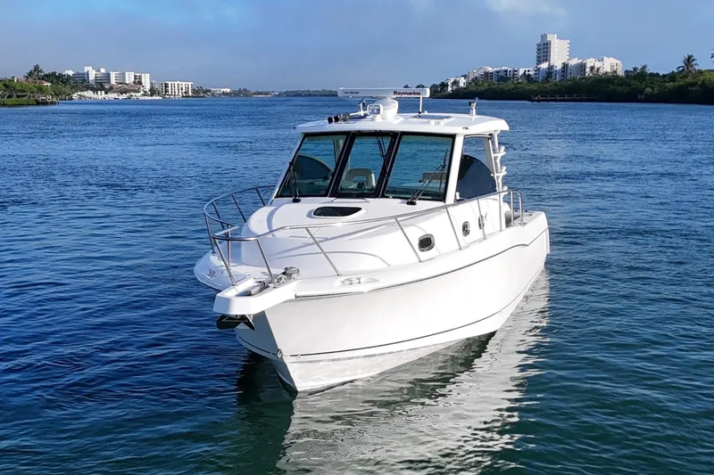 Whaler 345 Conquest - Loaded Yacht Photos Pics 2016 Boston Whaler 345 Conquest boat on calm water with cityscape background.