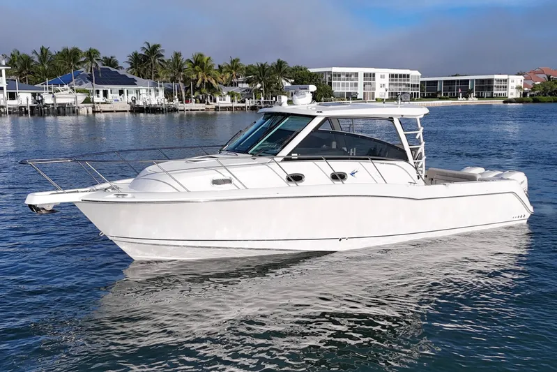Whaler 345 Conquest - Loaded Yacht Photos Pics 2016 Boston Whaler 345 Conquest boat on calm water near waterfront homes.