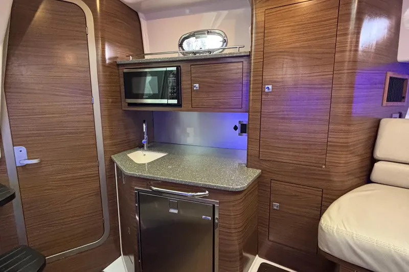 Whaler 345 Conquest - Loaded Yacht Photos Pics Interior of 2016 Boston Whaler 345 Conquest, featuring a compact kitchen with wood finish.