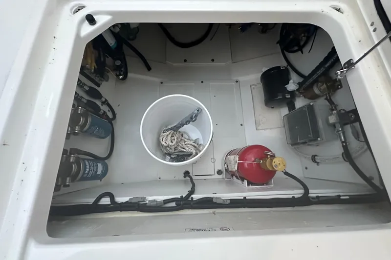  Yacht Photos Pics 2023 Pursuit DC 326 Dual Console storage compartment with fire extinguisher and rope bucket.