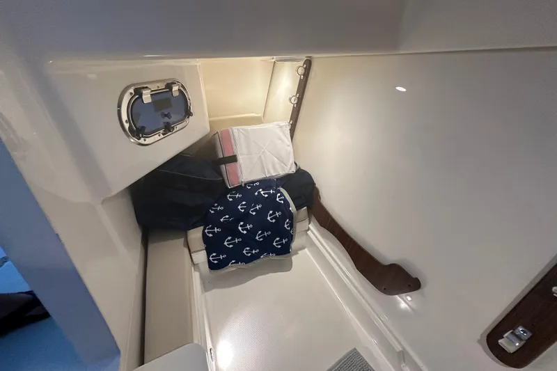  Yacht Photos Pics 2023 Pursuit DC 326 cabin interior with anchor-themed cushion and porthole.