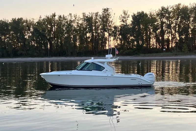  Yacht Photos Pics 2023 Pursuit DC 326 Dual Console boat on calm water at sunset.