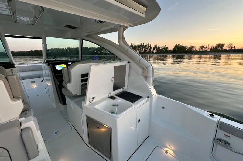  Yacht Photos Pics 2023 Pursuit DC 326 Dual Console boat interior at sunset on calm water.