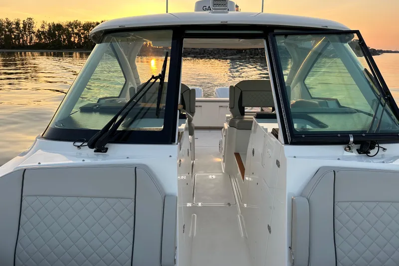  Yacht Photos Pics 2023 Pursuit DC 326 Dual Console boat at sunset on calm water.