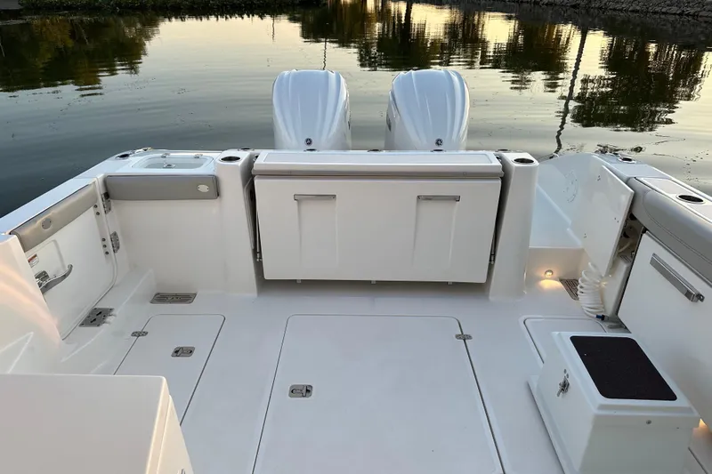  Yacht Photos Pics 2023 Pursuit DC 326 Dual Console boat interior with twin engines, docked on calm water.