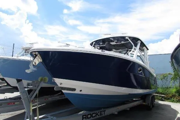 317-147 Brokerage Ray Yacht Photos Pics 2018 Robalo R317 Dual Console boat on trailer under a clear blue sky.