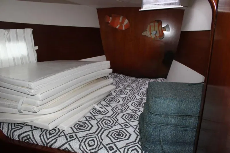 Mangata Yacht Photos Pics Interior cabin of 2003 Lagoon Power 43 with stacked cushions and geometric bedspread.
