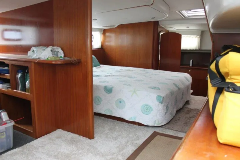 Mangata Yacht Photos Pics Interior of 2003 Lagoon Power 43 yacht with cozy bedroom and wooden furnishings.