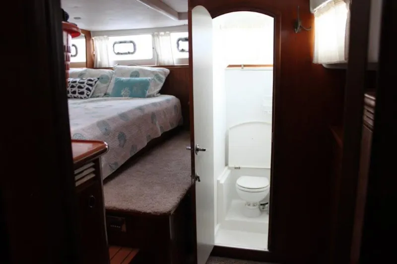 Mangata Yacht Photos Pics Interior of 2003 Lagoon Power 43 yacht with cozy bedroom and compact bathroom.