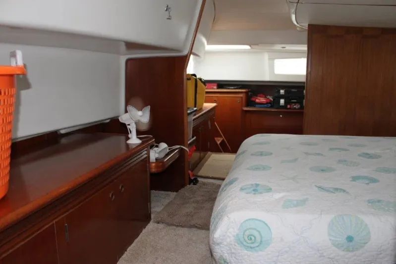 Mangata Yacht Photos Pics Interior of 2003 Lagoon Power 43 yacht cabin with bed and wooden cabinetry.
