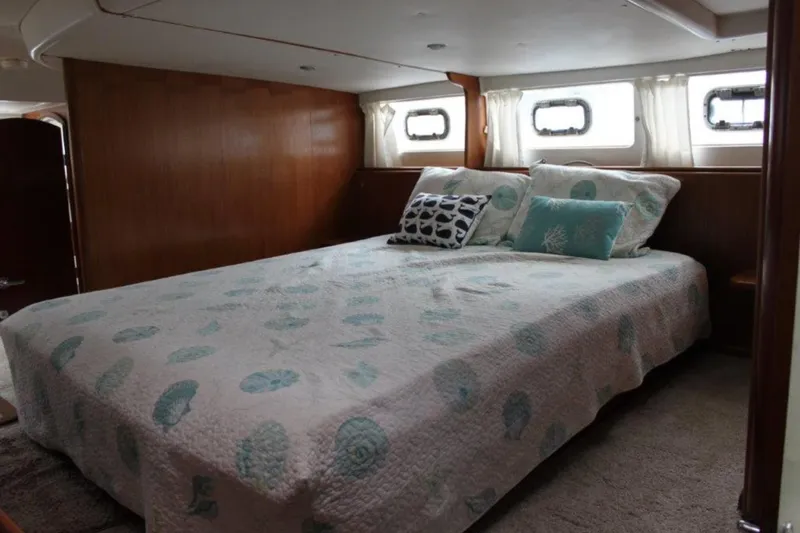 Mangata Yacht Photos Pics Cozy bedroom interior of 2003 Lagoon Power 43 yacht with nautical-themed bedding.