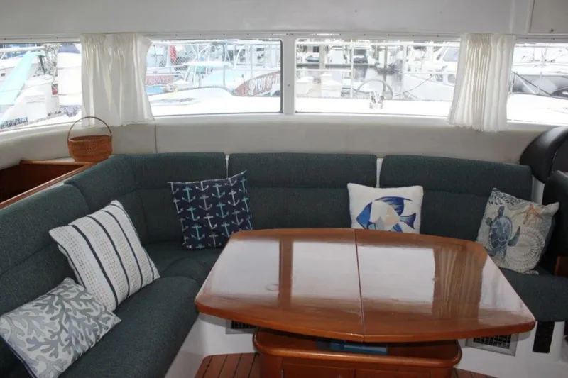Mangata Yacht Photos Pics Interior of 2003 Lagoon Power 43 yacht with cozy seating and nautical-themed cushions.
