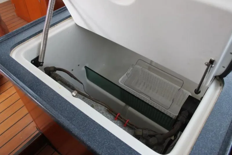 Mangata Yacht Photos Pics Open storage compartment on 2003 Lagoon Power 43 boat, featuring interior components and wooden flooring.