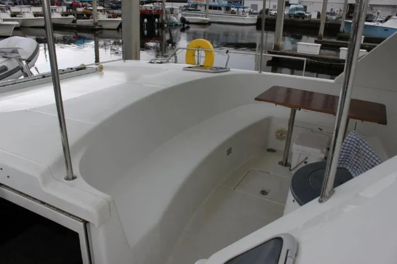 Mangata Yacht Photos Pics 2003 Lagoon Power 43 yacht cockpit with seating and table, docked at marina.